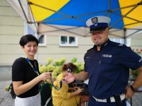 policjant wręcza gadżety mieszkance