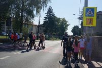 policjant z dziećmi na przejściu dla pieszych