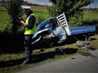 Pojazd po wypadku i policjant wykonujący czynności na miejscu