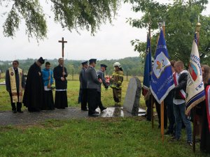 policjanci składają kwiaty przed tablicą pamięci