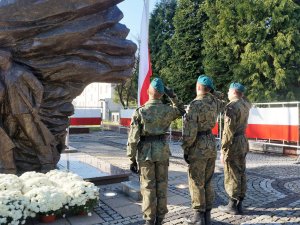 Trzech żołnierzy oddaje honor przed pomnikiem Bohaterów Powstań Śląskich