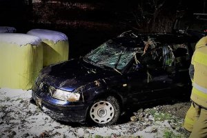 Zdjęcie przedstawia granatowy pojazd VW Passat, który został wyciągnięty z wody. Na zdjęciu widać przedstawiciela straży pożarnej.