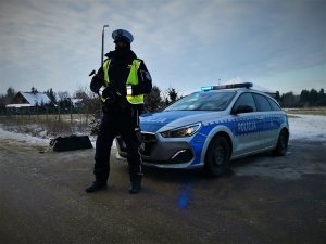 Zdjęcie przedstawia policjanta wydziału ruchu drogowego pełniącego służbę na posterunku blokadowym