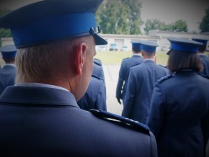 policjanci w mundurach galowych stoją tyłem, podczas uroczystej zbórki