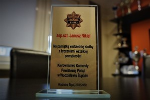 Statuetka na której widnieje napis &quot;asp.szt. Janusz Nikiel. Na pamiątkę wieloletniej służby z życzeniami wszelkiej pomyślności Kierownictwo Komendy Powiatowej w Wodzisławiu Śląskim. Wodzisław Śląski 22.02.2022&quot;