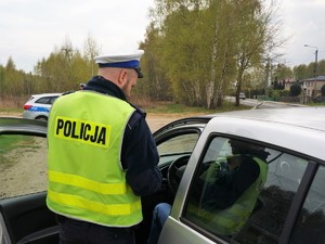 umundurowany policjant rozmawia z kierowcą zatrzymanego do kontroli drogowej samochodu