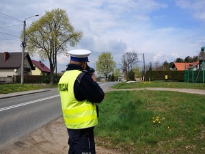 policjant mierzy prędkość przejeżdżających pojazdów