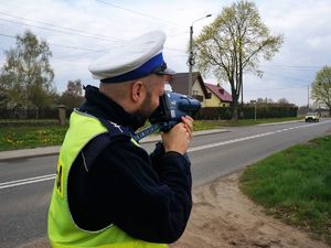 policjant mierzy prędkość przejeżdżającym pojazdom