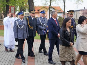 w uroczystym orszaku idą przedstawiciele Straży Miejskiej i Policji w mundurach galowych, za nimi idzie ksiądz