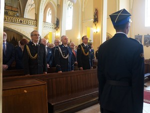 w kościele w ławce stoją funkcjonariusze straży pożarnej i policji w galowych mundurach