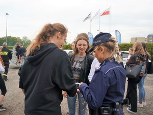 policjantka zakłada kajdanki młodej dziewczynie, inna dziewczyna się przygląda