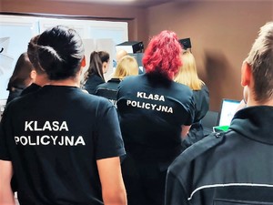 uczniowie klas policyjnych znajdują się w pomieszczeniu technika kryminalistyki, słuchają, jak opowiada o swojej pracy