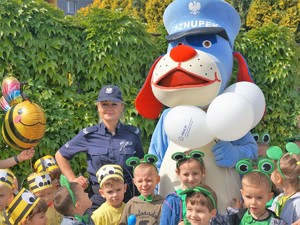 policjantka i maskotka śląskiej Policji stoją obok przedszkolaków