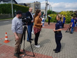policjantka udziela wywiadu, dziennikarka trzyma w ręce mikrofon, obok stoi kamerzysta