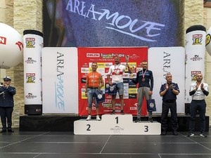 na podium stoi trzech mężczyzn w strojach rowerowych, obok nich stoi Komendant Wojewódzki Policji w Rzeszowie, nadinspektor Dariusz Matusiak, który bije brawo