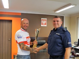 Pierwszy Zastępca Komendanta Powiatowego Policji w Wodzisławiu Śląskim ściska dłoń policjantowi ubranemu w koszulkę rowerową