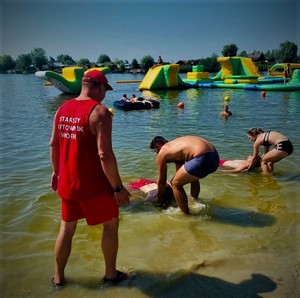 Zdjęcie przedstawia pokaz ratowników WOPR wyciągania tonącego z wody