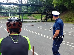 policjant wskazuje trasę przejazdu po torze rowerowym rowerzyście