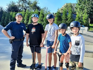 na zdjęciu grupa dzieci stoi obok policjanta, pozują do wspólnego zdjęcia na skateparku