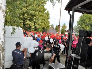 policjanci rozdają balony uczestnikom festynu bawiącym się przed sceną podczas koncertu