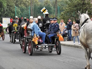 dorożką jadą mężczyzna i kobieta, na przeciwko nich siedzą policjanci w mundurach galowych