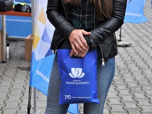 kobieta trzyma torebkę promocyjną z napisem &quot;Starostwo Powiatowe&quot;