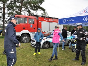 policjanci przyglądają się, jak kobieta idzie mając założone alkogogle