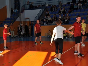 podczas meczu siatkówki policjant w sportowym stroju przebija piątkę z uczennicą grającą z nim w drużynie