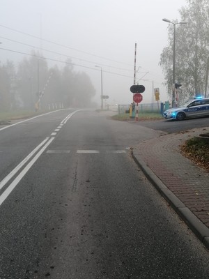 przejazd drogowy kolejowy, obok stoi policyjny radiowóz