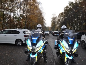 na parkingu przy cmentarzu stoją policjanci na motocyklach