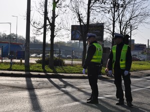 dwaj policjanci stoją na skrzyżowaniu, kierują ruchem