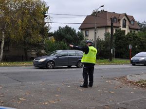 policjant stoi przy drodze, kieruje ruchem