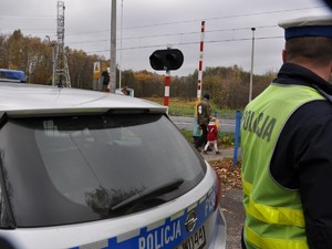 policjant obserwuje ruch pieszych w kierunku cmentarza