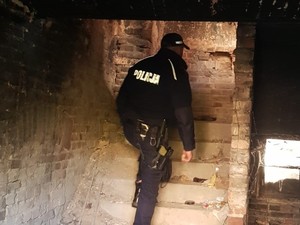 policjant wchodzi po schodach pustostanu