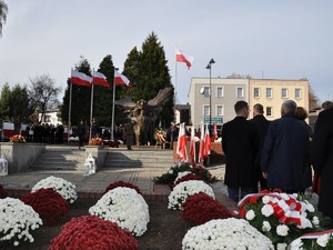 przed pomnikiem Powstańców Śląskich trwają uroczystości, miejsce ozdobione jest kwiatami w kolorze białoczerwonym