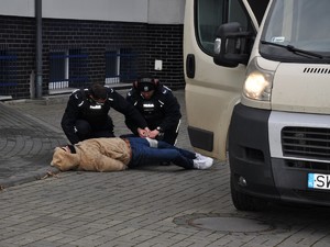 policjanci udzielają pomocy medycznej obezwładnionemu napastnikowi