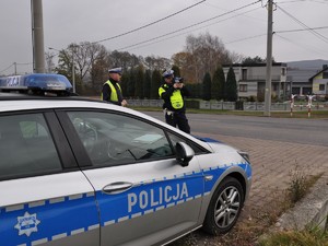 policjant przy drodze mierzy prędkość, z jaką poruszają się pojazdy