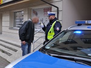 policjant bada stan trzeźwości mężczyzny, obok nich stoi policyjny radiowóz