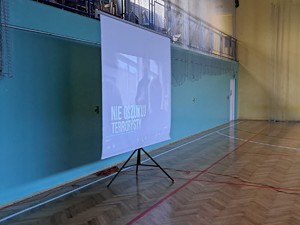na sali gimnastycznej widać rzutnik, na którym wyświetla się pierwsza slajd prezentacji mulitmedialnej