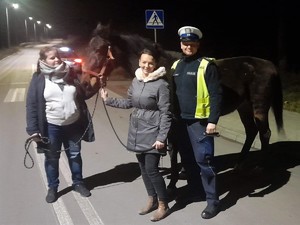 policjant stoi obok kobiet, które prowadzą konia