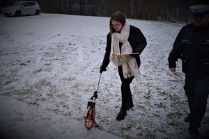 praktykantka wykonuje pomiary na miejscu zdarzenia drogowego