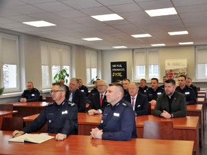 policjanci siedzą w ławkach na sali odpraw podczas narady