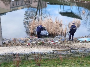 w stawie znajduje się uszkodzony pojazd, obok stoją policjanci