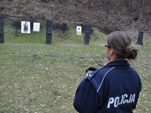 policjantka stoi na stanowisku do treningu strzeleckiego, patrzy w kierunku tarczy