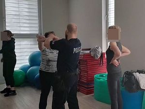 policjant pokazuje kobiecie chwyty samoobrony