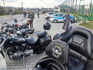 na parkingu samochodowym stoją zaparkowane motocykle i policyjny radiowóz