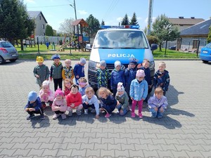 do wspólnego zdjęcia pozują przedszkolaki na tle radiowozu