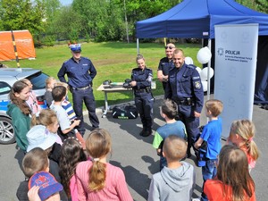 policjanci rozmawiają z grupą dzieci podczas festynu