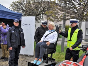 Zdjęcie przedstawia kobietę, która siedzi na urządzeniu do symulacji wypadków.