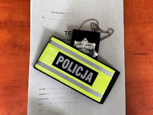 Odznaka policyjna oraz opaska odblaskowa z napisem policja